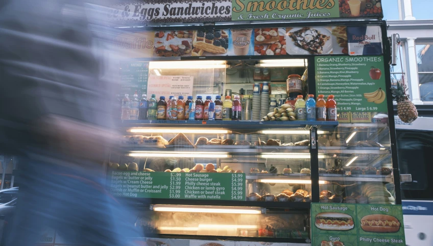 a man walking past a sandwich shop display