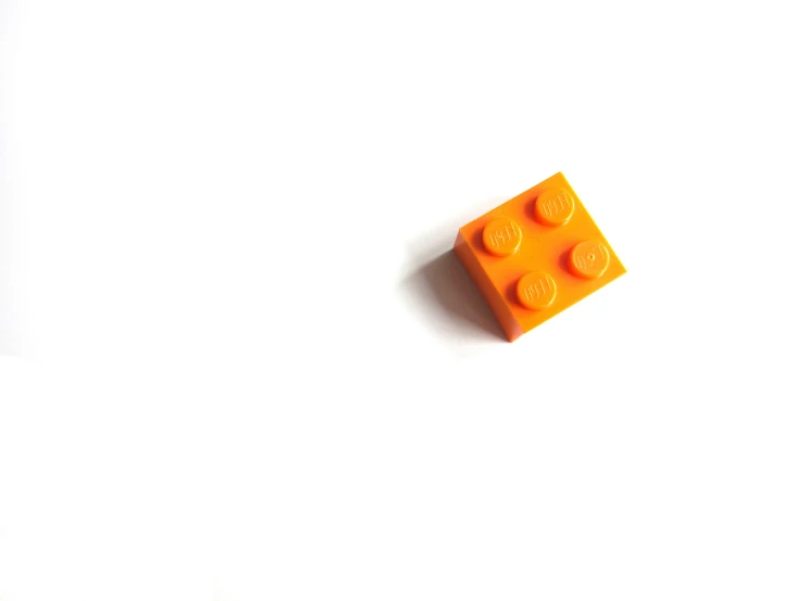 an orange lego block with two little dots on it