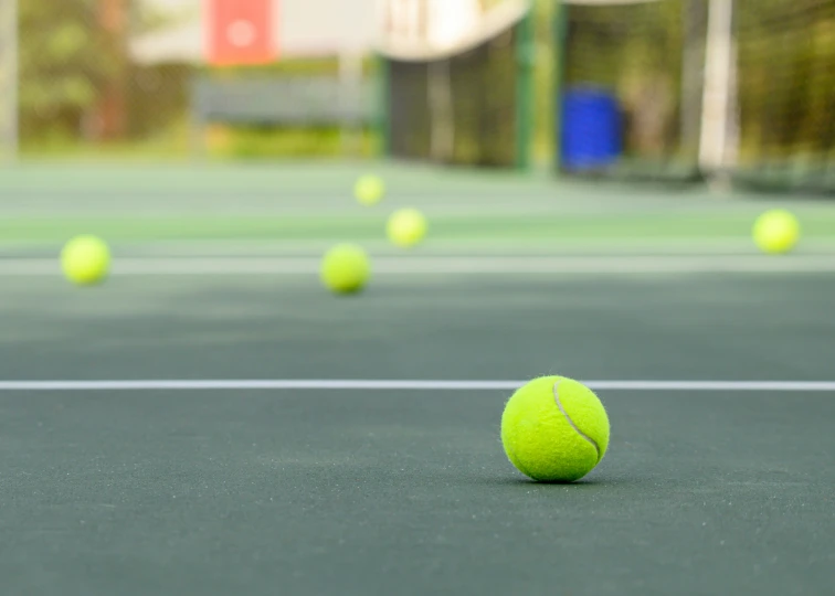 an tennis ball is on the ground as many others are playing