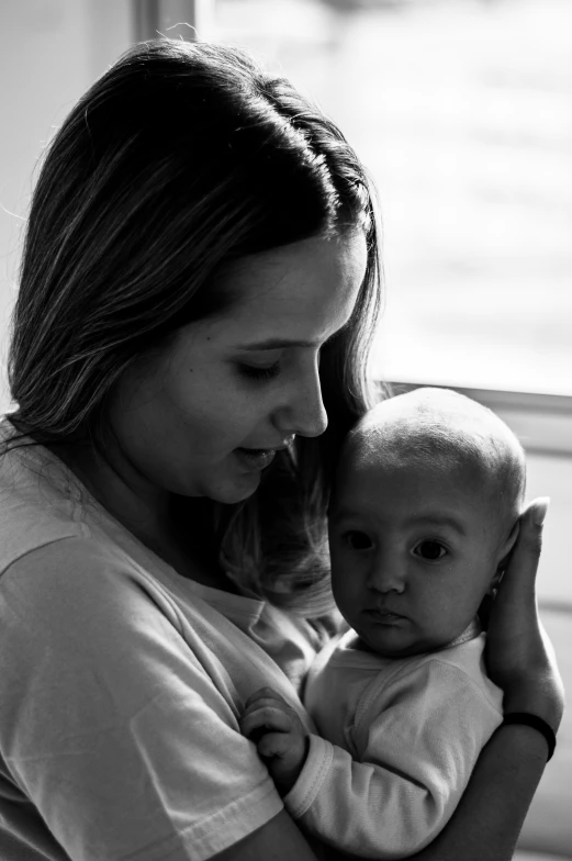 a woman holding a baby while holding its mother