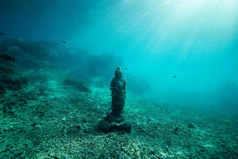 a statue is shown underwater by the rocks