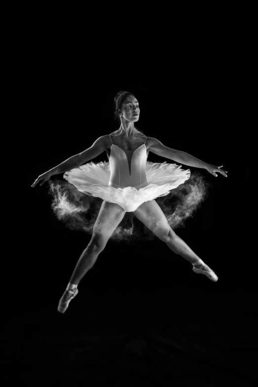 a young ballerina in action with her arms out, in mid air