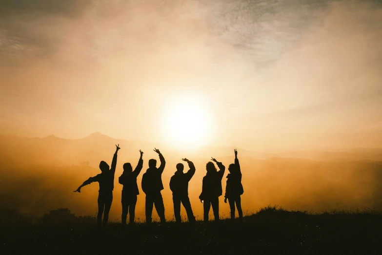 a group of people standing in the dirt with their arms up