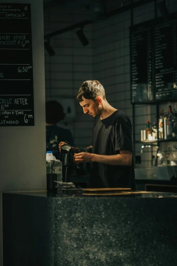 a man standing in front of a coffee shop counter
