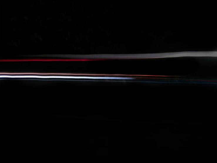 a car drives through the dark with streaks of light