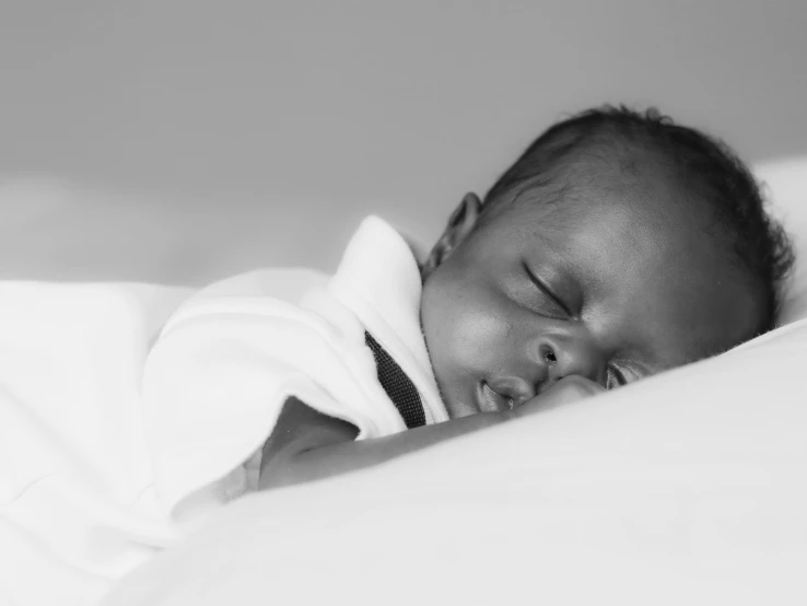 a small infant is sleeping on a bed