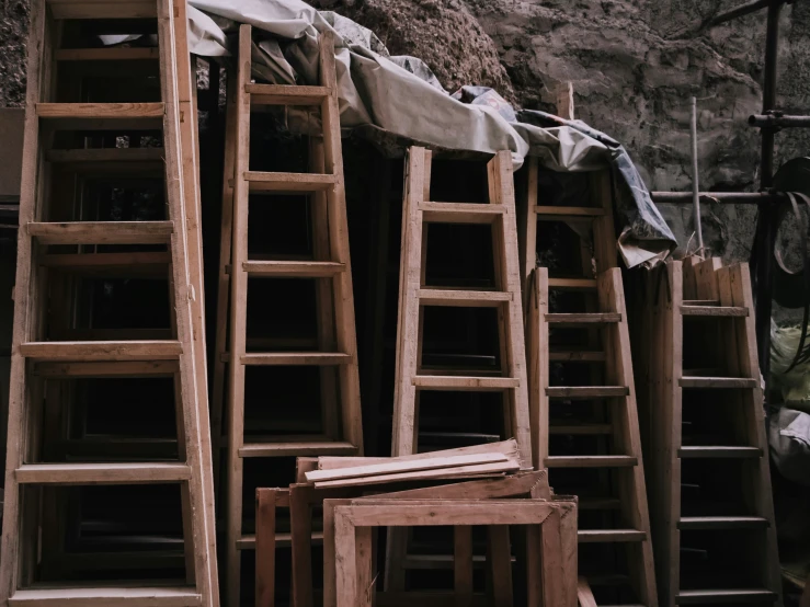 wooden chairs are lined up in a pile