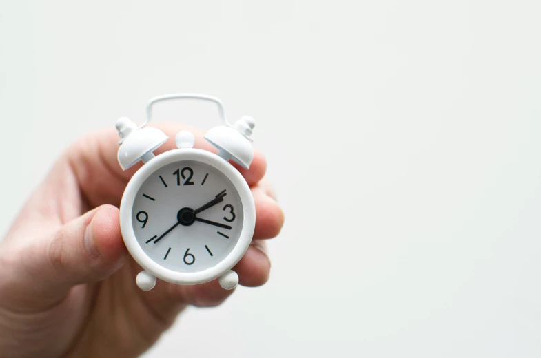 a white alarm clock that has been made out of clay