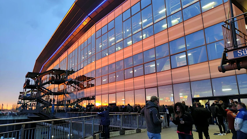 a large crowd is standing outside the building looking at people