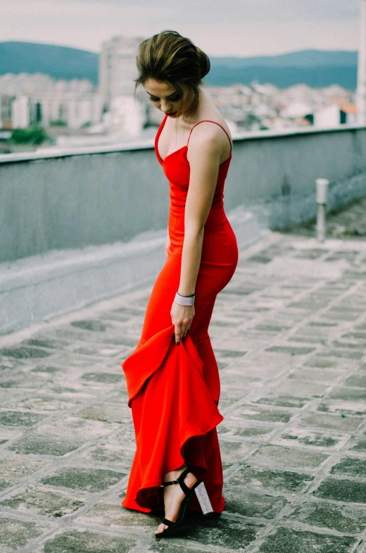 a woman in a red dress on a ledge