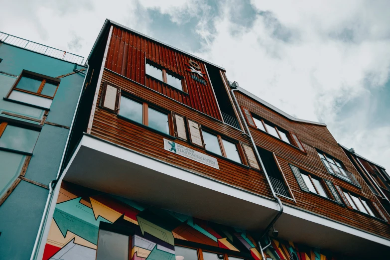 a tall multicolored building with windows on the side