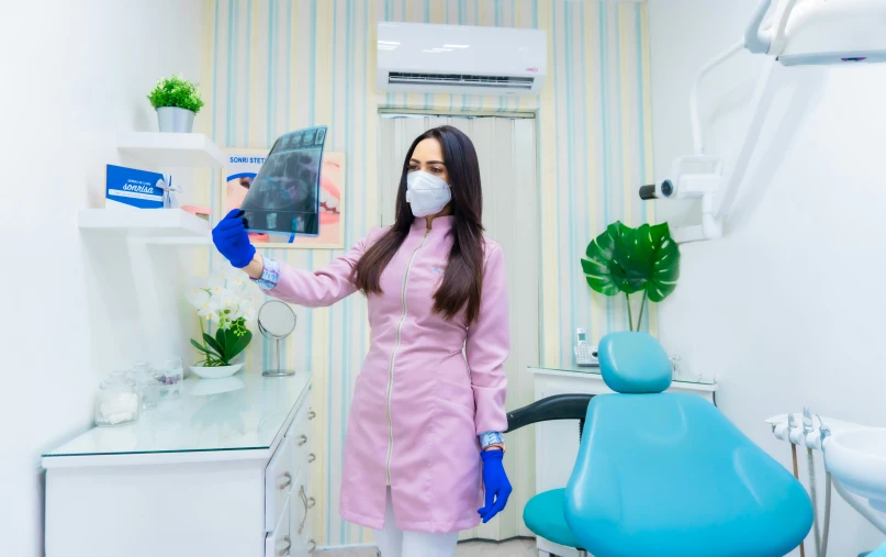 woman wearing a protective face mask and pink coat in a room