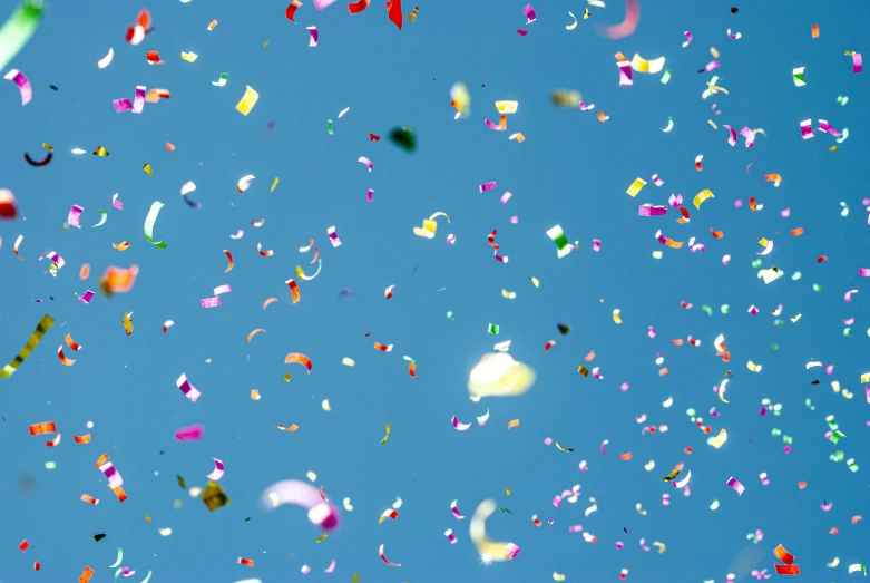 a lot of colorful confetti flying in the sky