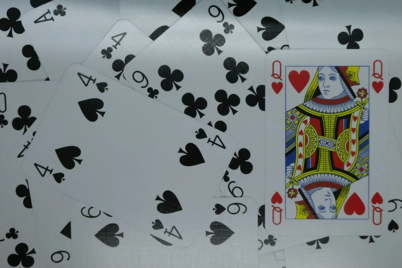 playing cards and spades on a metallic table