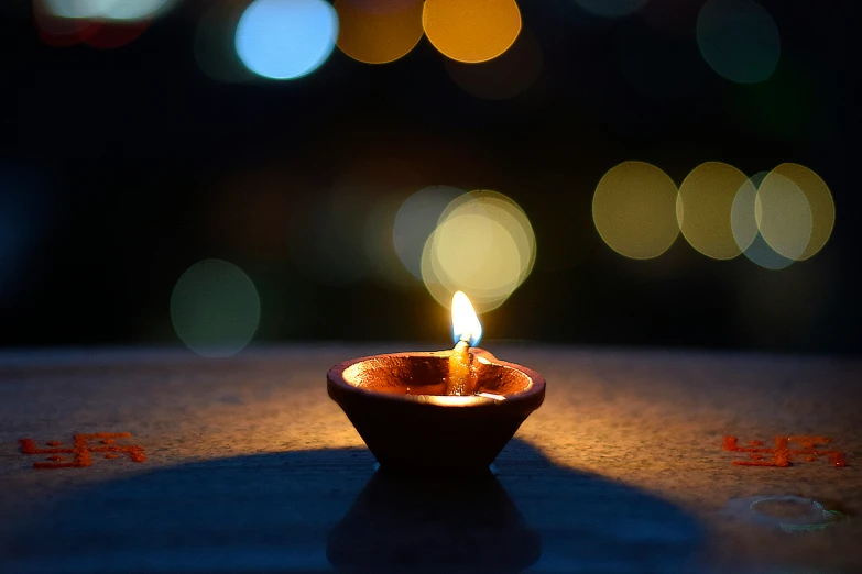a small candle sits on a table at night