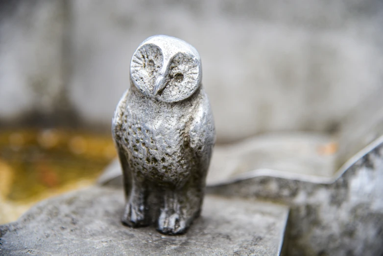 an animal statue sitting on a cement base