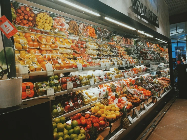 a shop filled with lots of produce next to windows