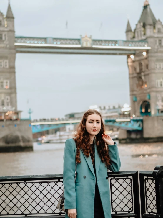 a woman posing with a city view behind her