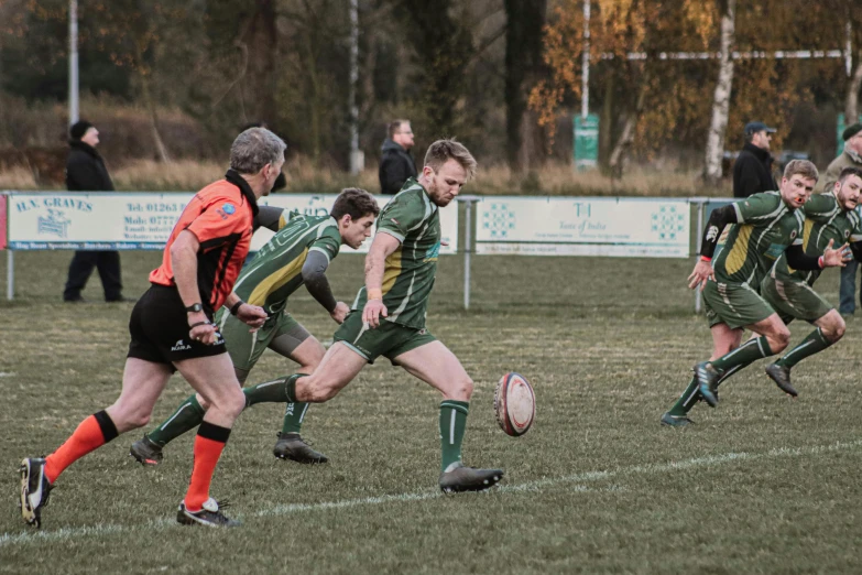 group of people playing a game of rugby on the field