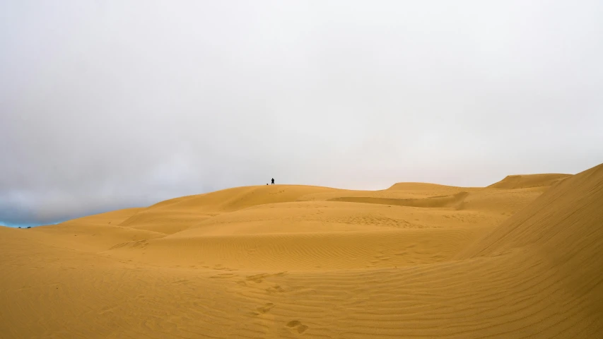 the person is standing on a high hill in the desert