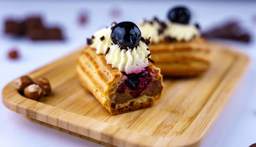 some toast with whipped cream and black cherries on top