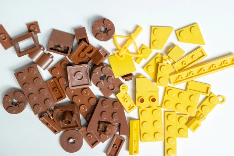 several brown lego parts are arranged on a white surface