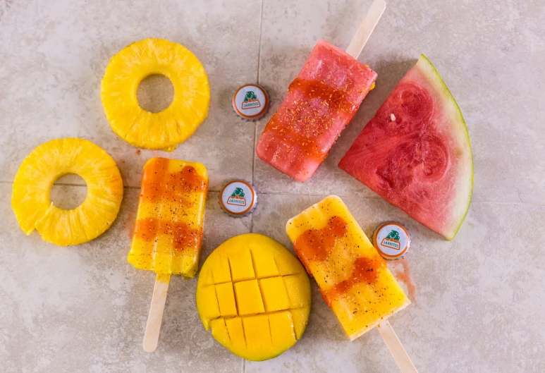 popsicles, watermelon, and pineapple are arranged on the table