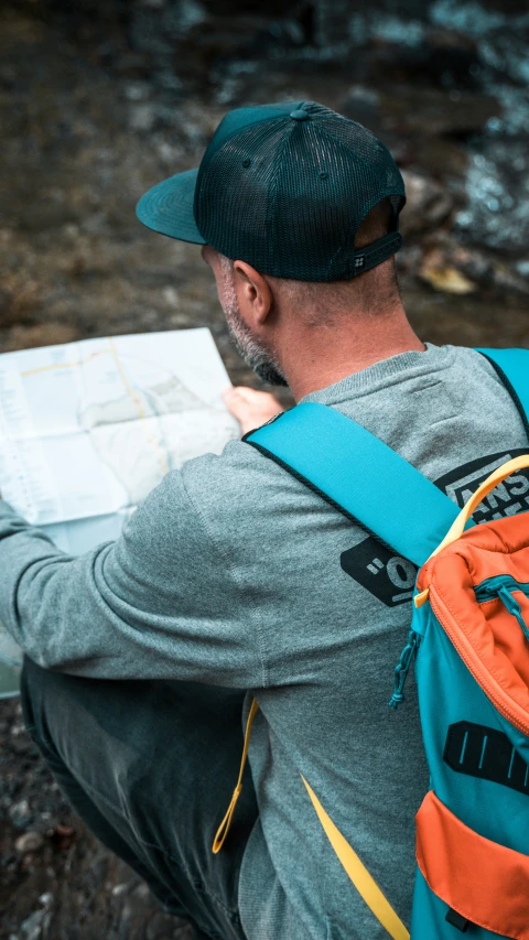 man with a book and backpack looking at the map