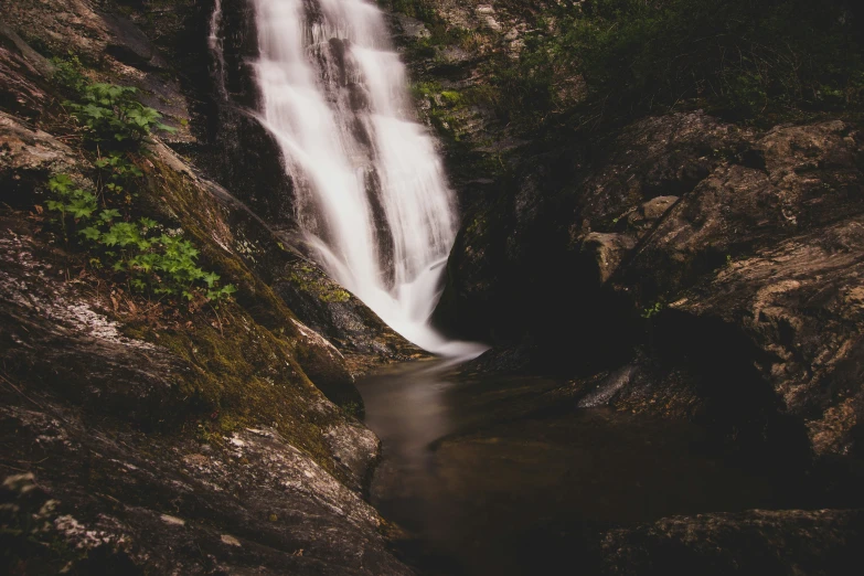 a waterfall with water running into the side of it