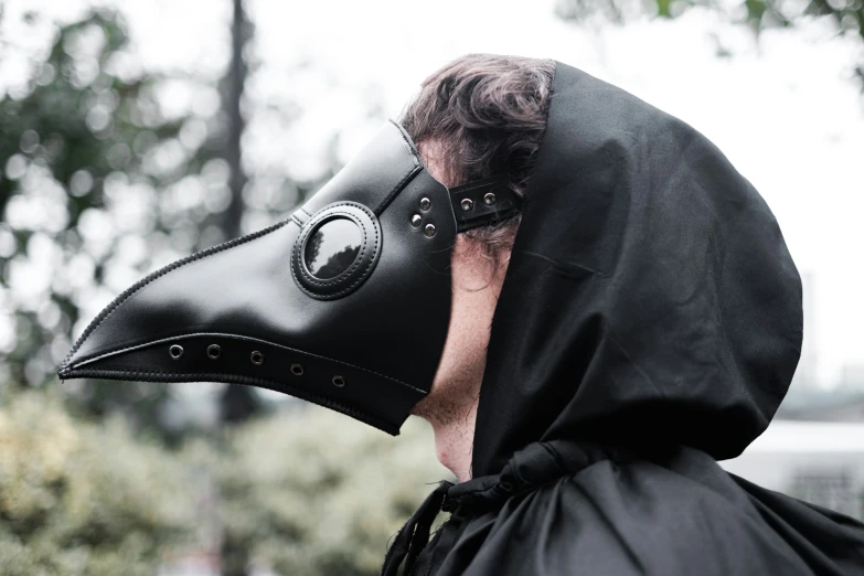 a woman wearing a large plague mask