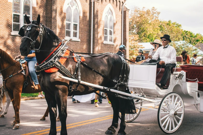 a horse drawn carriage next to a man on the sidewalk