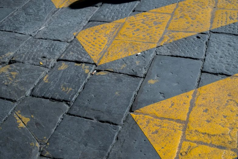 there is a black and yellow arrow on the pavement