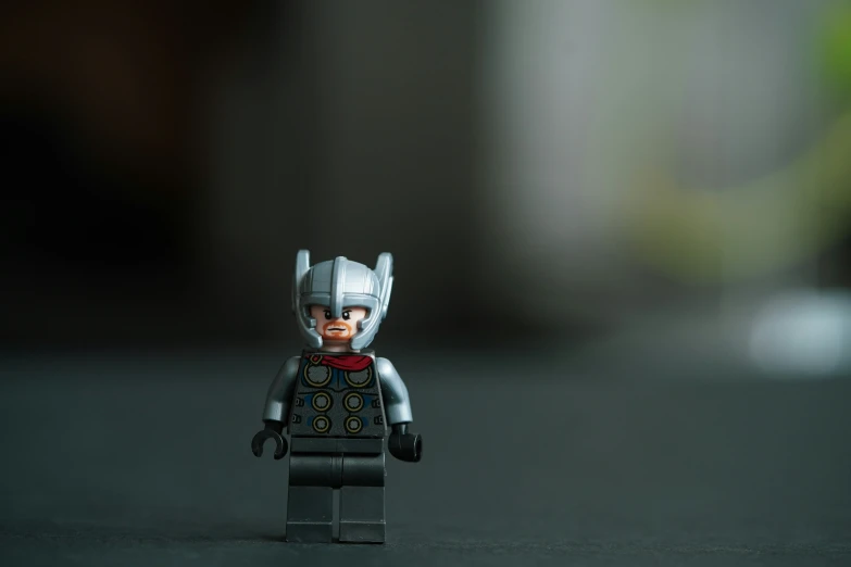 a lego batman in armor sits on a table