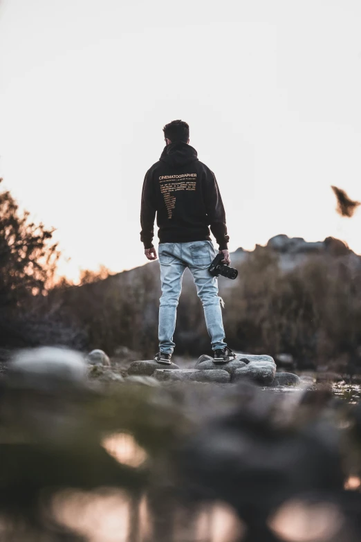 the man is standing on a rock in the field