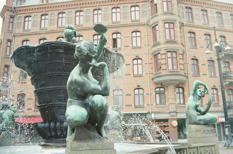 fountain with two bear statues and building in the background