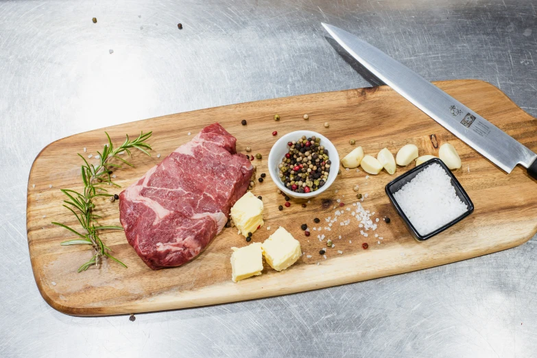 meat and various ingredients on top of wooden  board with knife