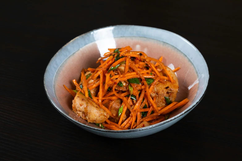 a bowl of carrots and meat on a table