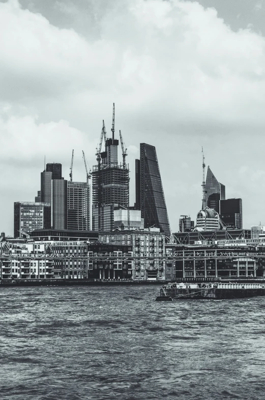 a boat sailing down the river in front of a tall city