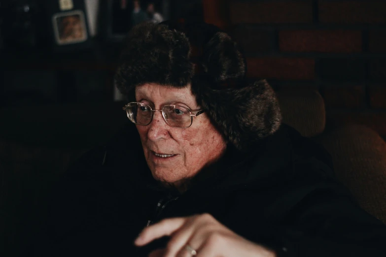 a close up of a person wearing a hat on a couch