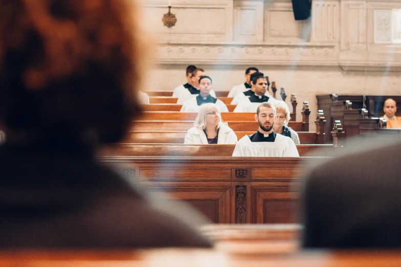 a man sitting in front of an audience on top of a lecture hall