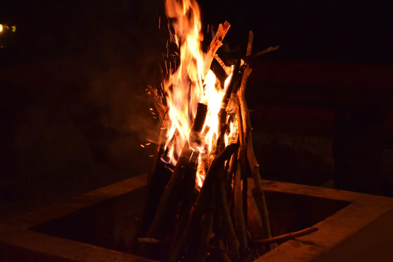 fire lit in the night with wood sticks