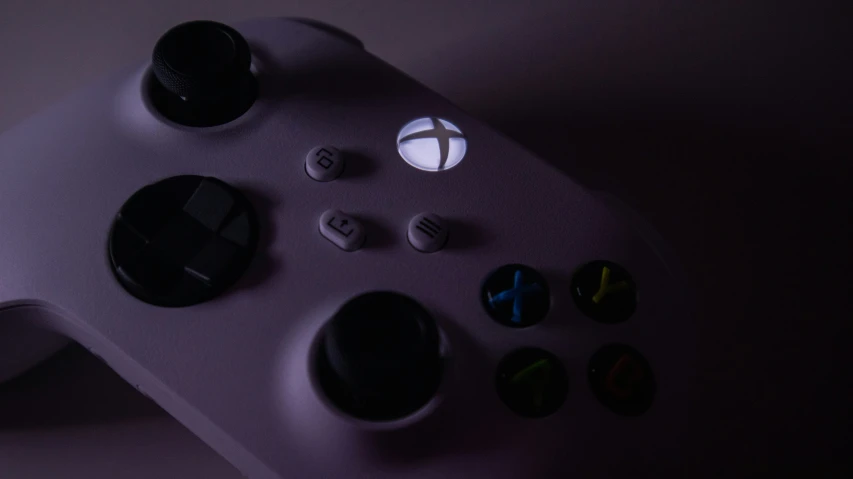 a white controller with black s is shown