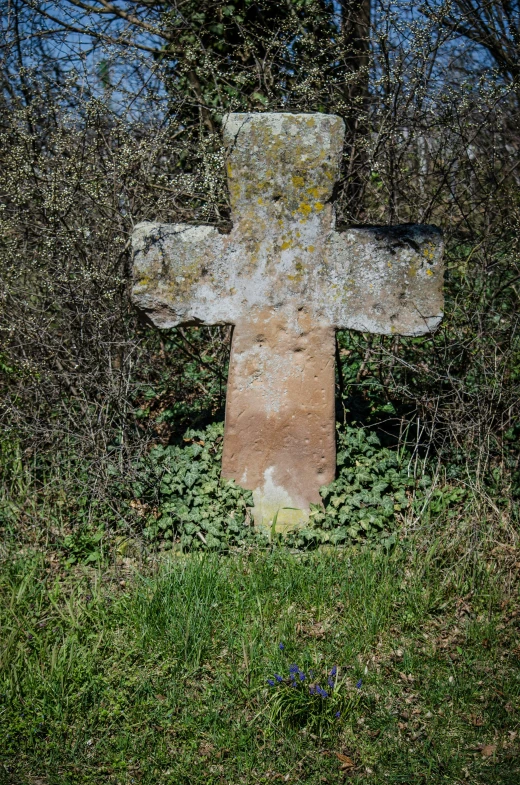 an old cross embedded in a grassy area