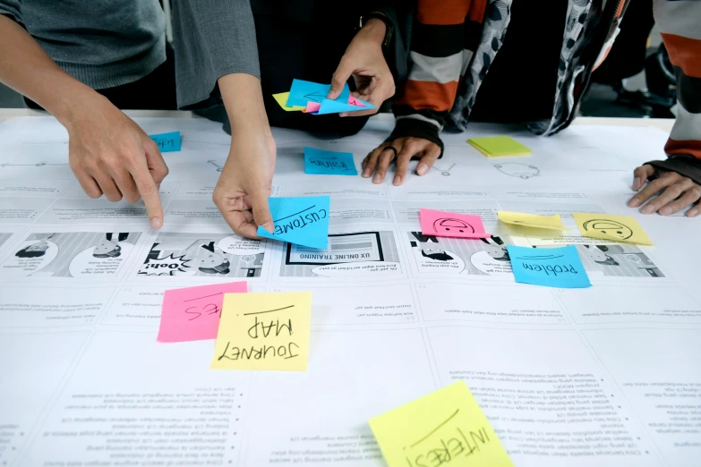 several people looking at post it notes on a table