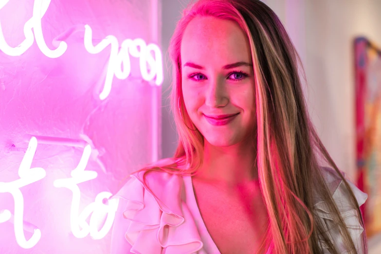 a woman standing in front of a neon sign