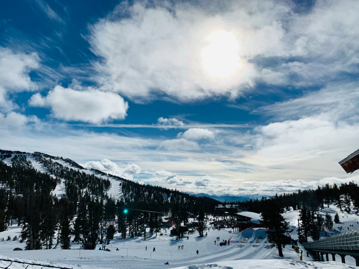 a sun and blue sky over the mountains