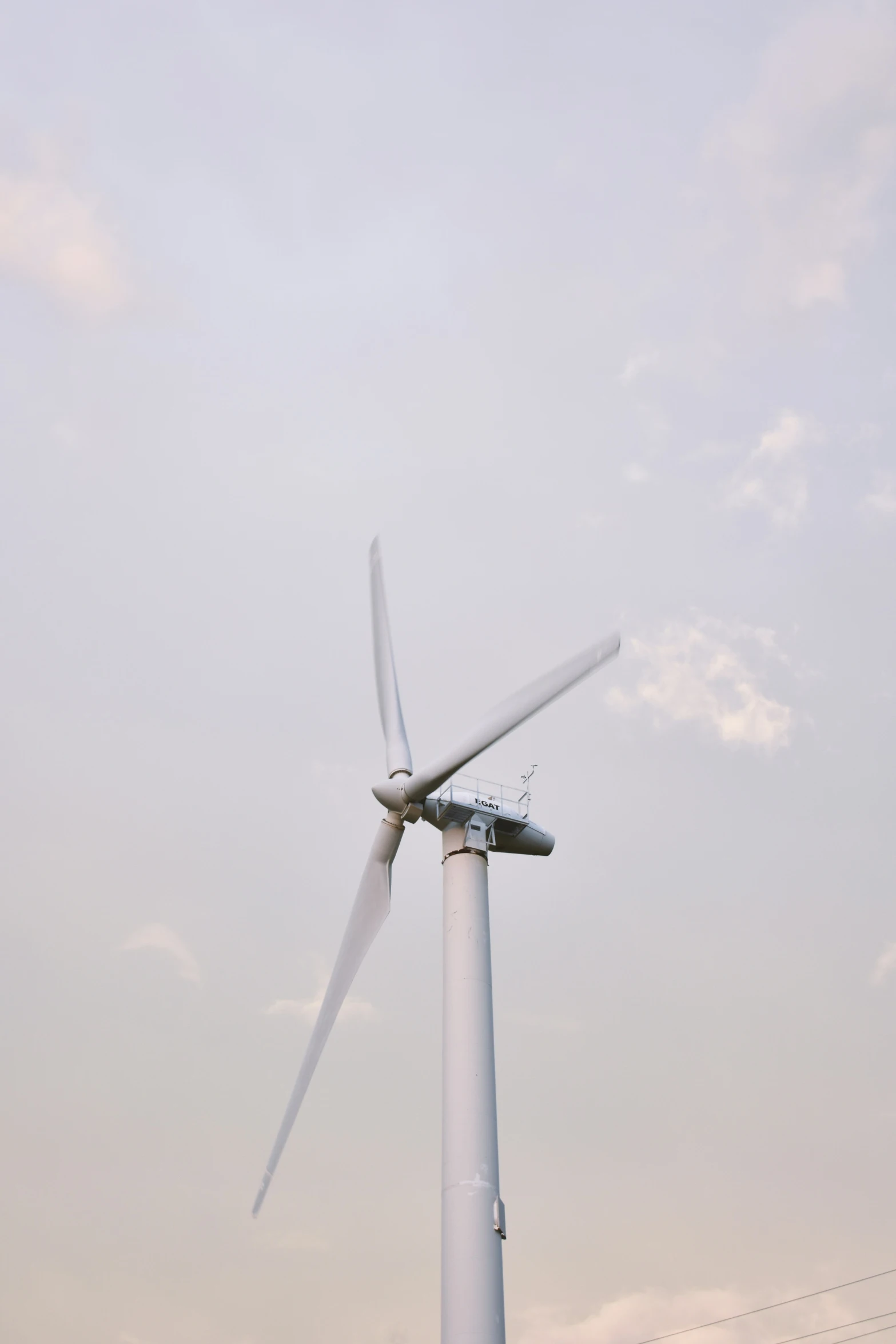 a wind turbine sitting next to a power line