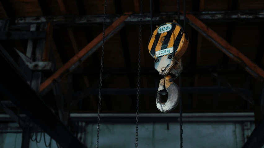 a metal piece hangs on a chain with a sign above