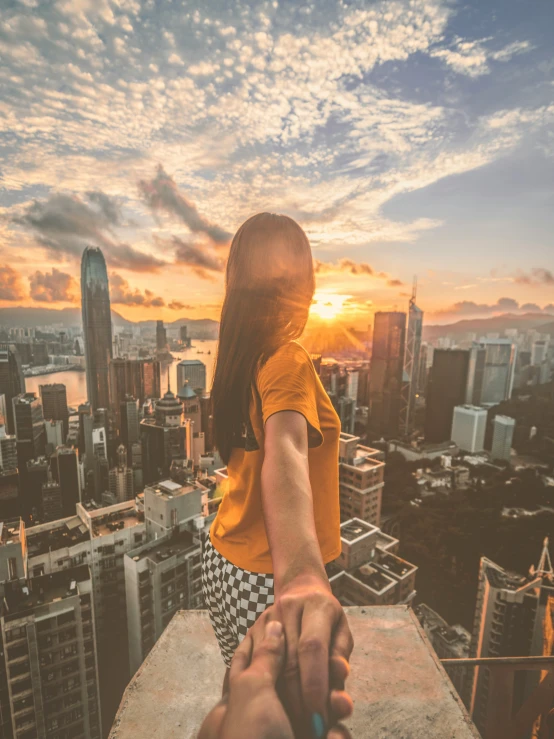 man and woman holding hands on top of a building