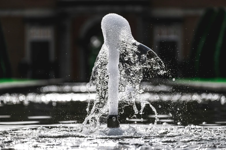 a white pipe splashing in water near a building